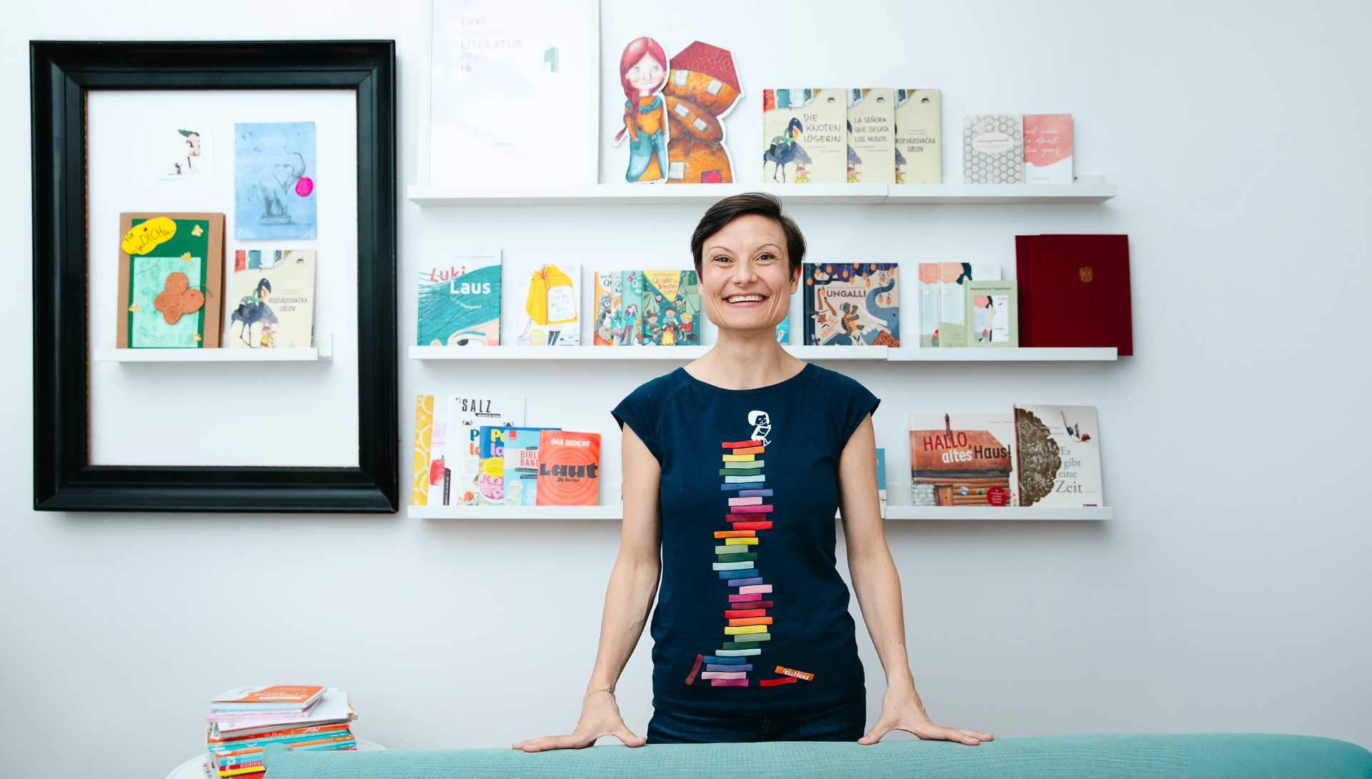 Lena Raubaum steht l&auml;chelnd vor einer B&uuml;cherwand