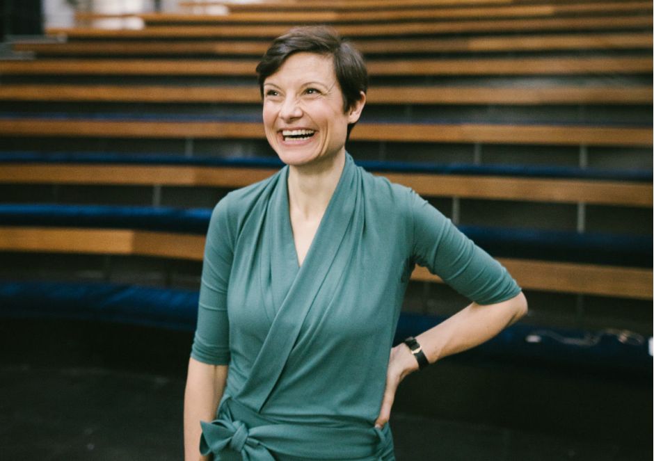 Lena Raubaum lacht herzlich vor einer Trib&uuml;ne.